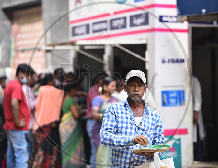 An Old Man Posing to camera while having meals brought from GHMC Annapurna Meal Counter.
