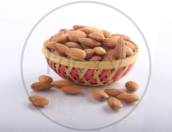 Tasty almonds in a bowl on white background