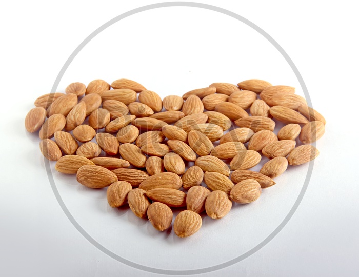 Tasty almonds on white background with love shaped design