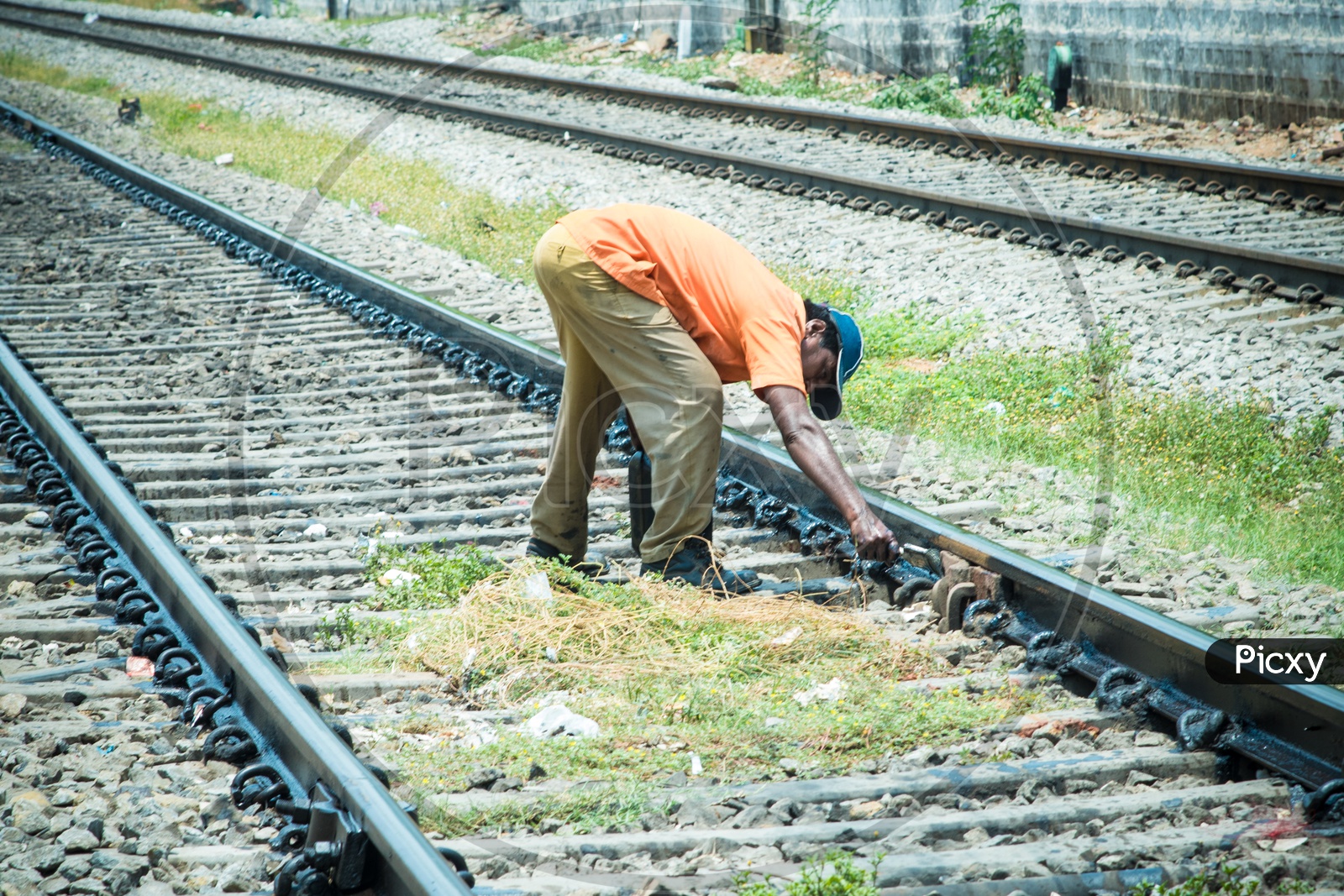 Railway maintenance worker painting and greasing railway tracks