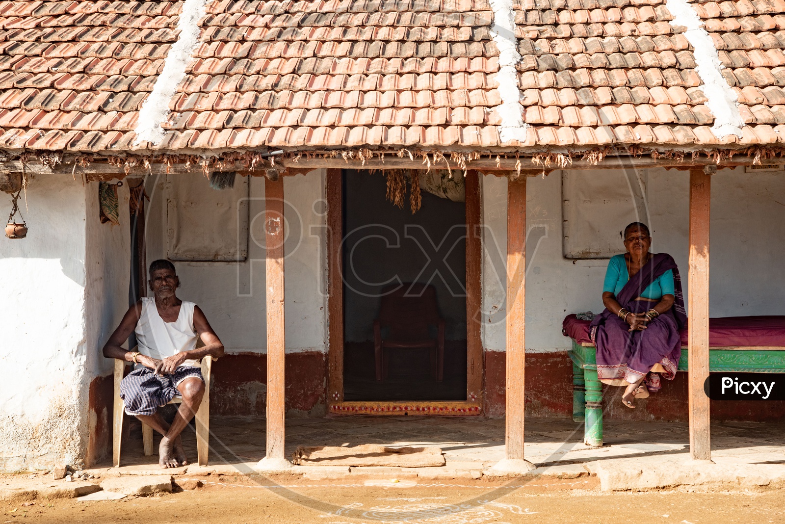 Elderly couple relax outside their house in a village in Peddagudem