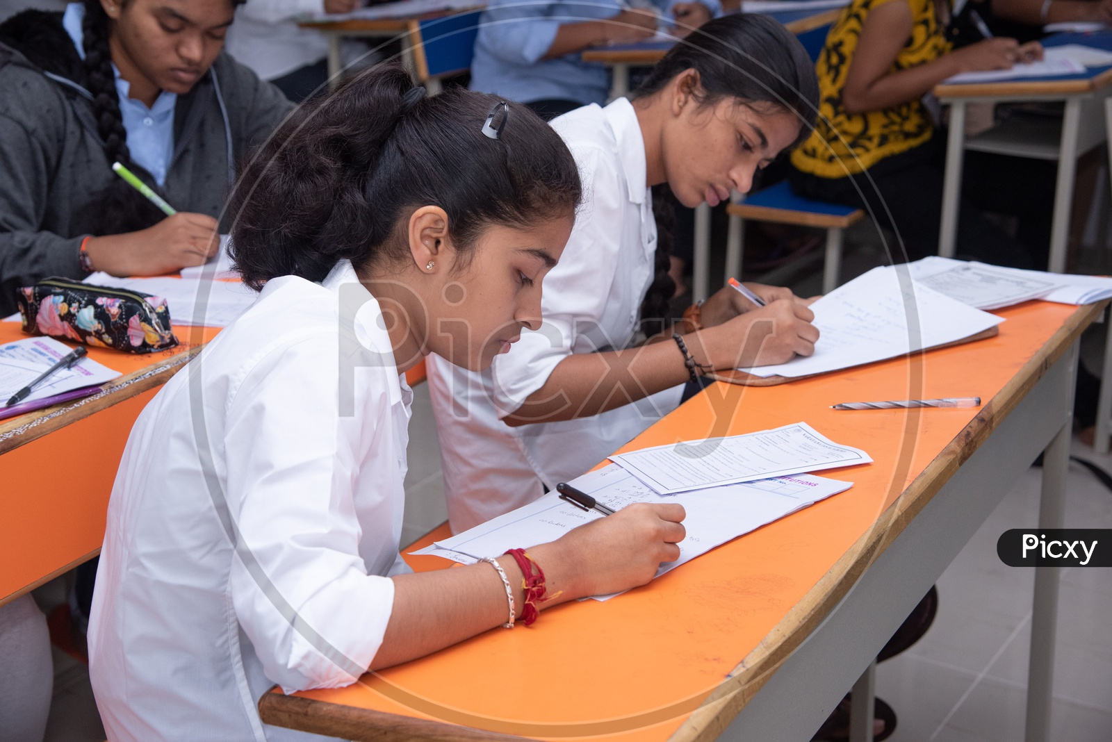 Girl student writing exam at an educational institute.