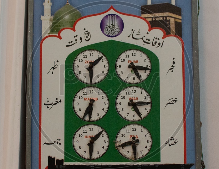 Traditional display board showing prayer timings at a Mosque
