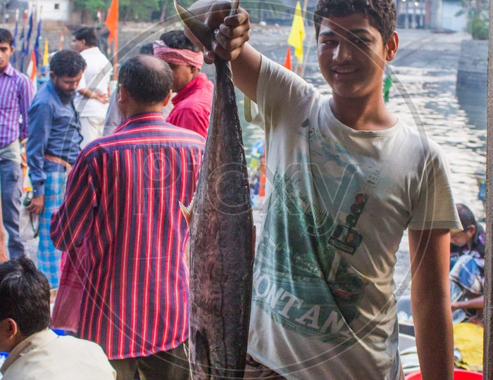 An uncle showing the fish they just brought from the sea