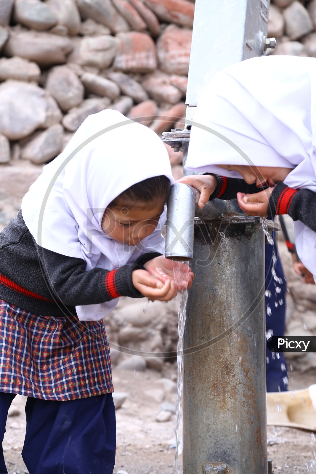 kids Drinking Water at a hand pump