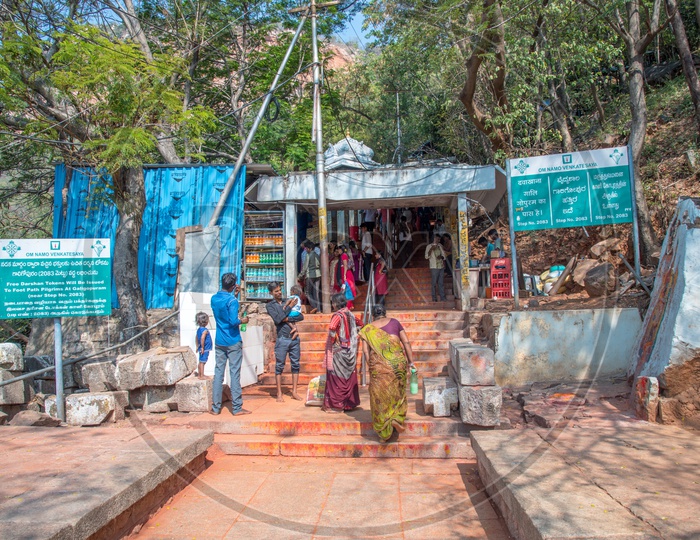 Pilgrims and few sign boards with information at  Lord Venkateswara Swamy Temple Walk way, Tirupati