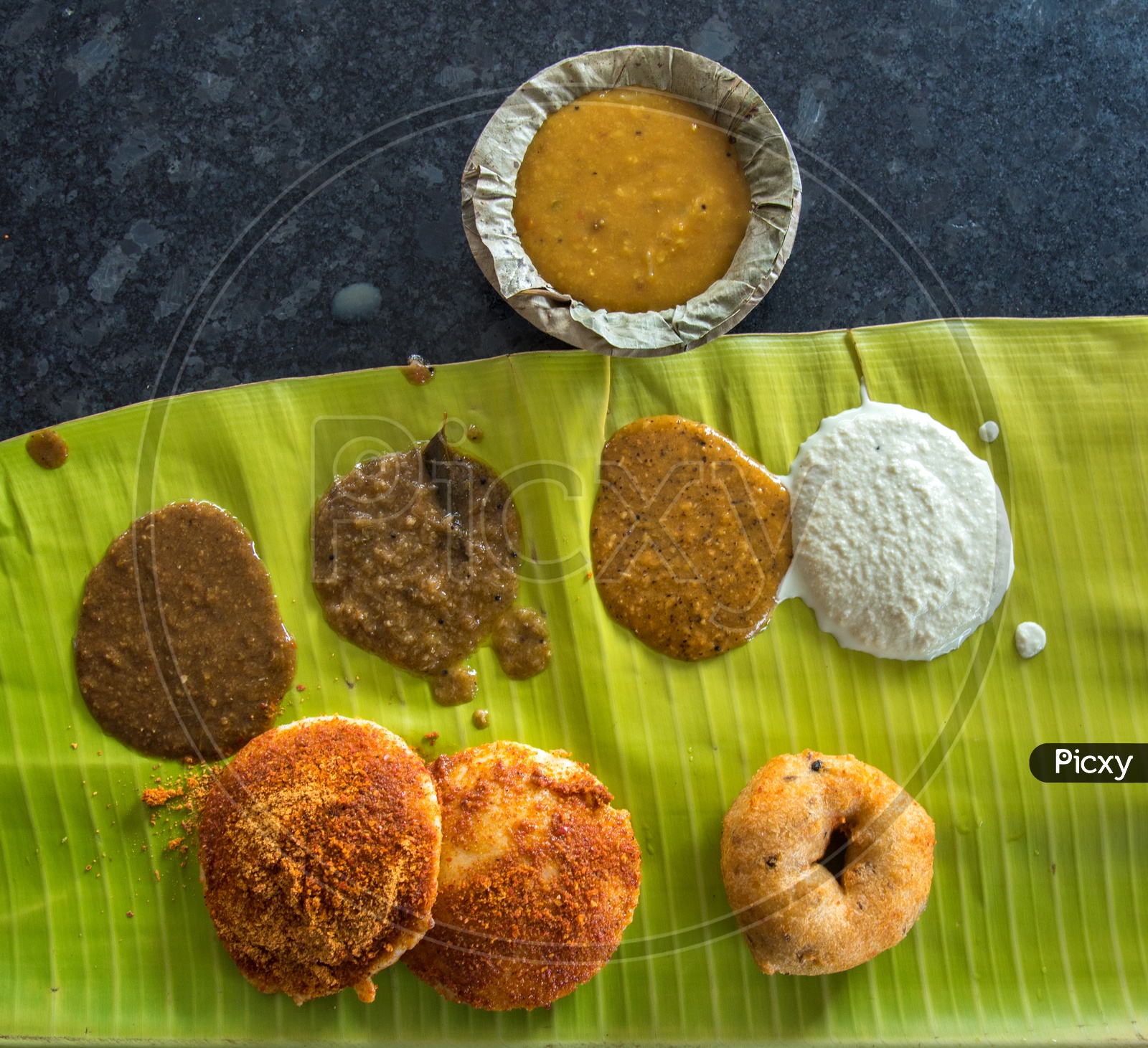 Ghee Podi Idly and Wada with different Chutneys and Sambar.