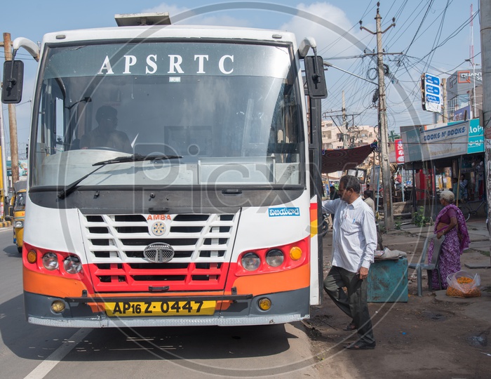APSRTC Bus in a Bus Stop, Passengers hopping in