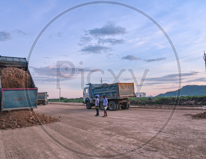 Construction vehicles dispatching Soil on a Road, near Neerukonda. SRM University
