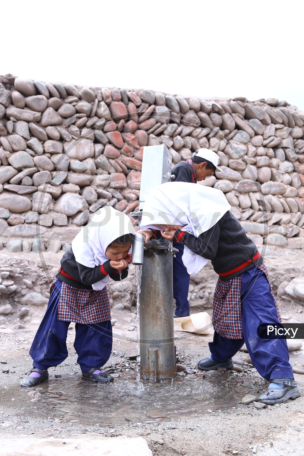 kids Drinking Water at a Hand pump