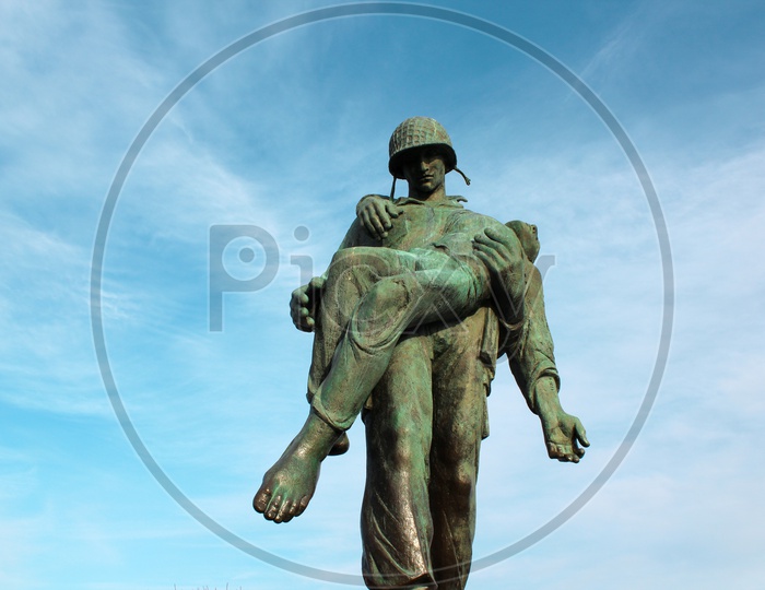Statue of a soldier carrying a World War II Survivor.