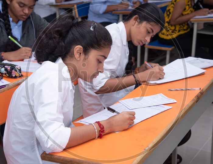 Girl student writing exam at an educational institute.