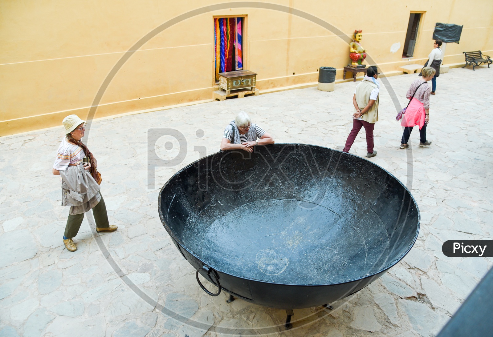 Tourist admiring large cooking vessel at Amer Fort