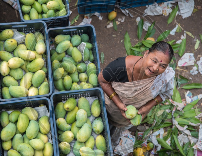 A woman selling mangoes at Kothapet Fruit market.