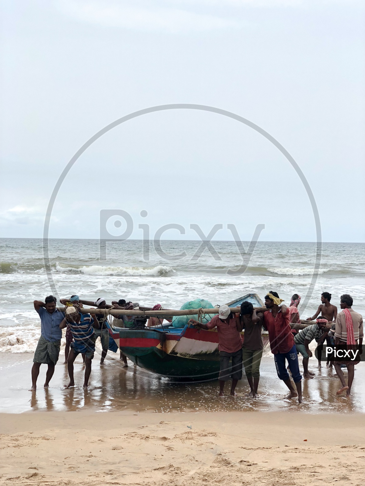 Team work. Fishermen pulling the boat to the coast.