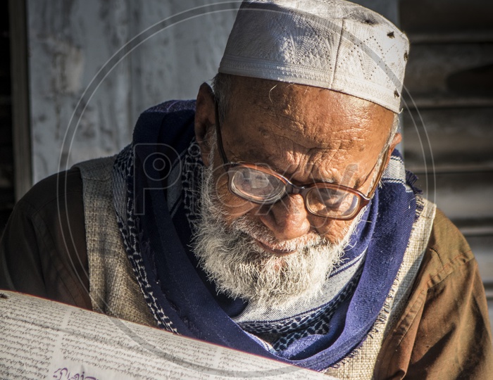 Old Muslim Man reading News paper