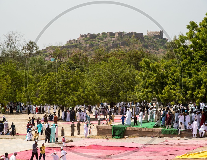 Prayer meet at Qutb Shahi Tombs during Ramadan Eid, Golconda Fort in background