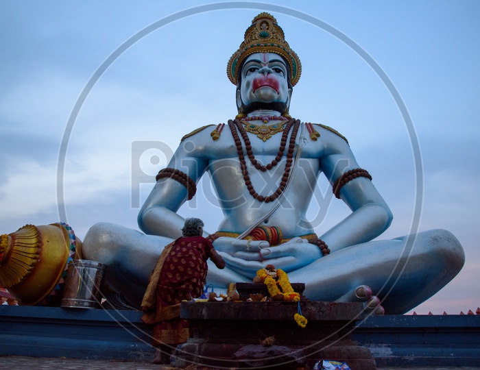 A woman praying to Hanuman