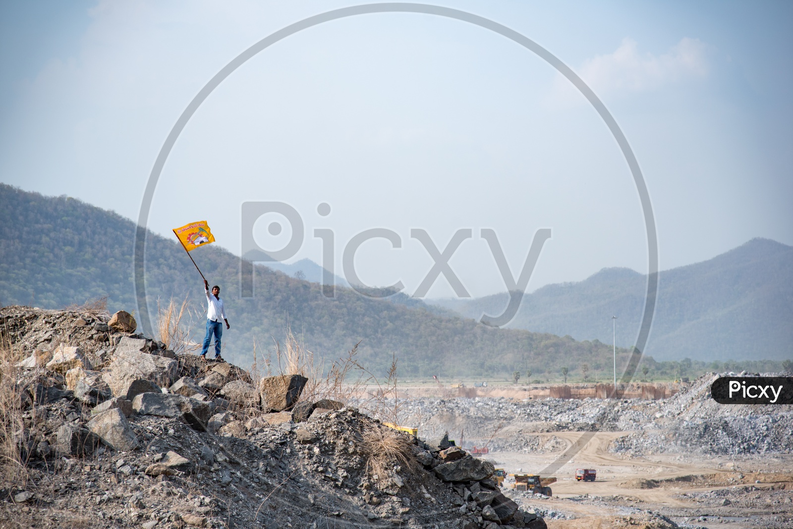 A TDP Supporter Waving TDP Party Flag at Polavaram Irrigation Project Dam Site.