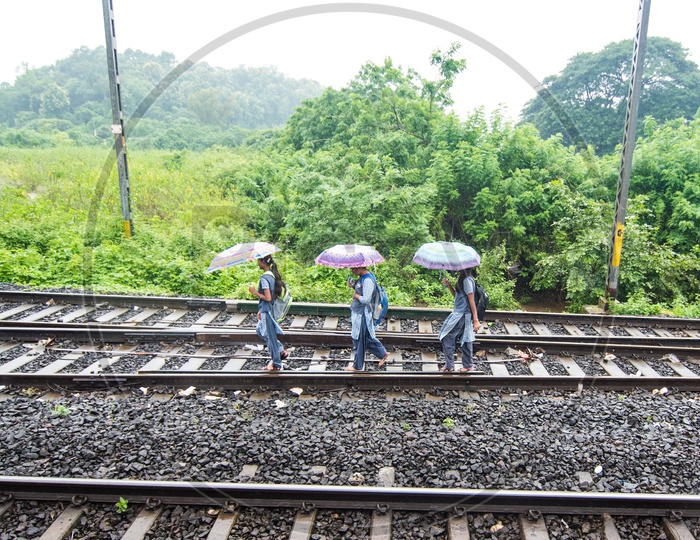 School chidren walking on Railway tracks during Monsoon in Maharastra