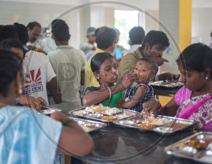 mother feeding her child in anna canteen