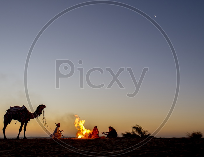 People sit around bonfire in Desert, Rajasthan