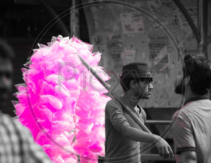 A man selling cotton candy on the streets for a living