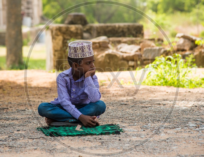 A small boy seeking alm at Qutb Shahi Tombs during Eid