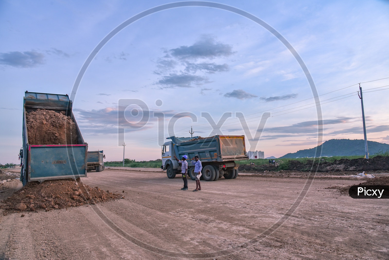 Construction vehicles dispatching Soil on a Road, near Neerukonda. SRM University