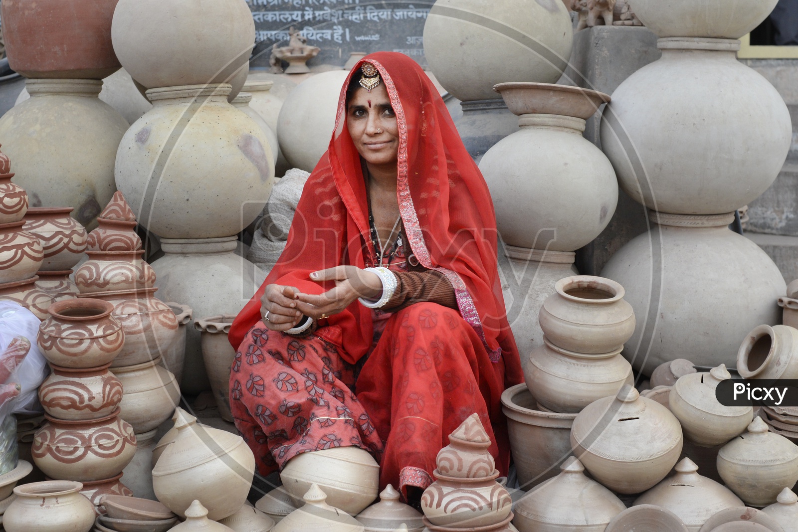 Rajasthani Woman in Traditional Attire Selling Clay Pots