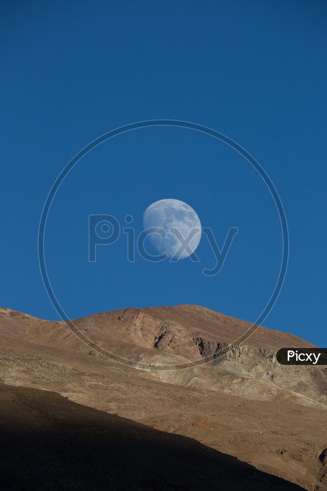 The moon rises over the mountains at Spiti Valley