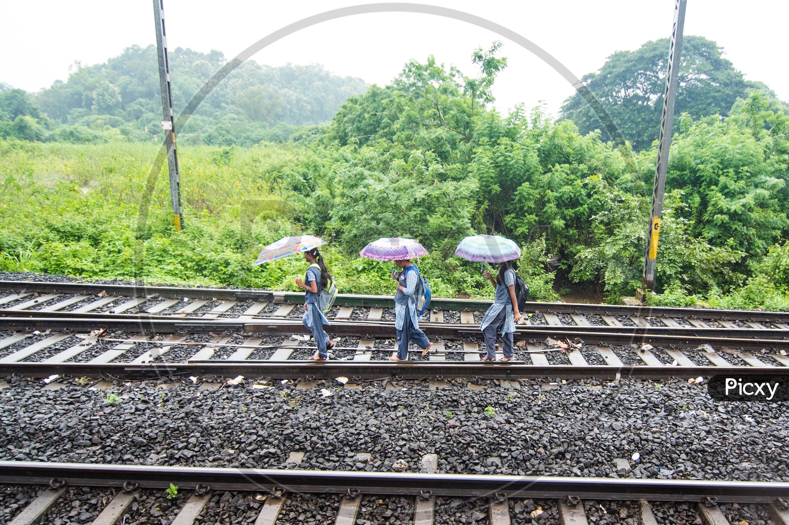 School chidren walking on Railway tracks during Monsoon in Maharastra