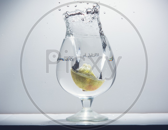 Lemon dropped into a glass of water