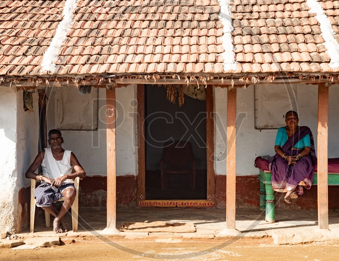 Elderly couple relax outside their house in a village in Peddagudem