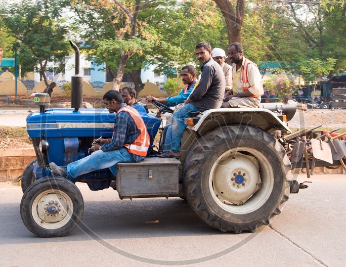 HMDA Workers & Gardeners riding on a tractor