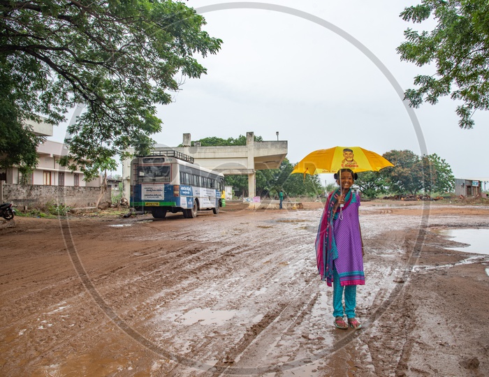 A girl walking in rain with an umbrella with Nara Chandra Babu naidu's image on it