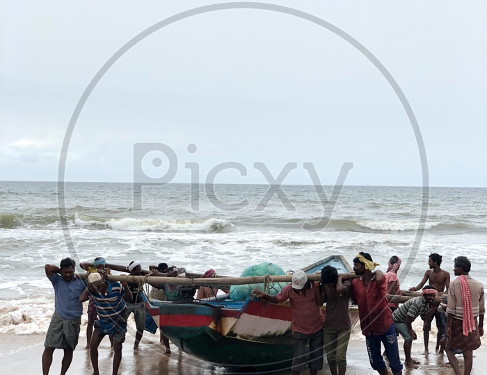 Team work. Fishermen pulling the boat to the coast.