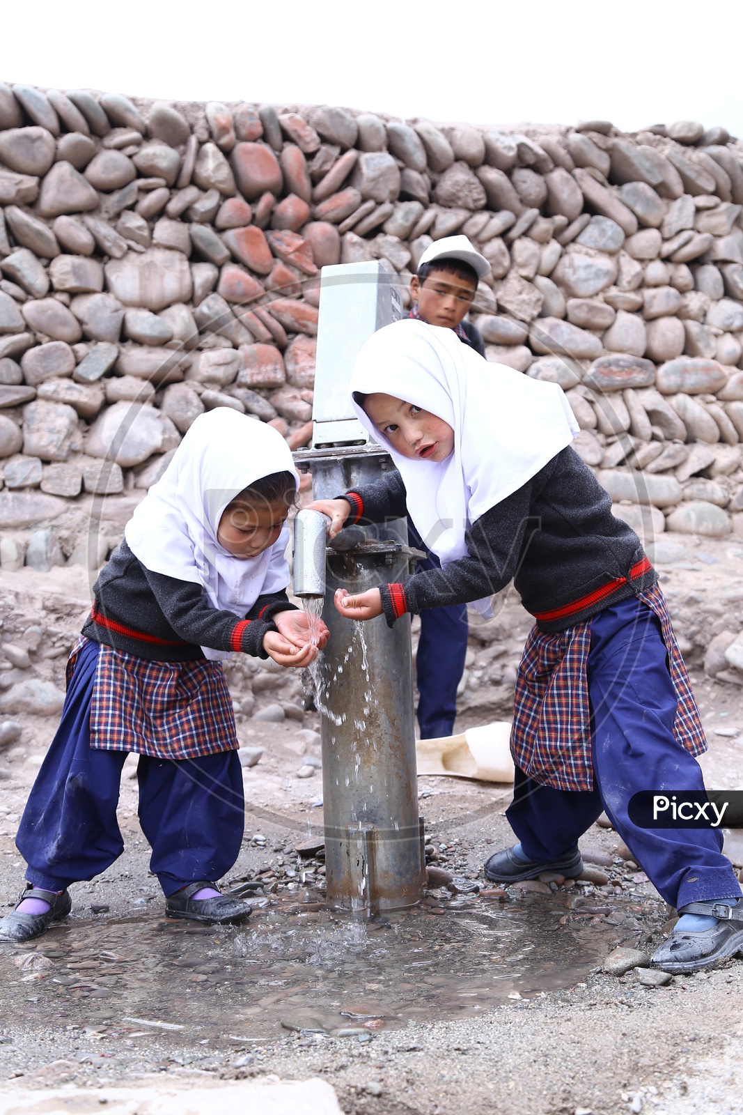 School Kids drinking water using Hand Pump