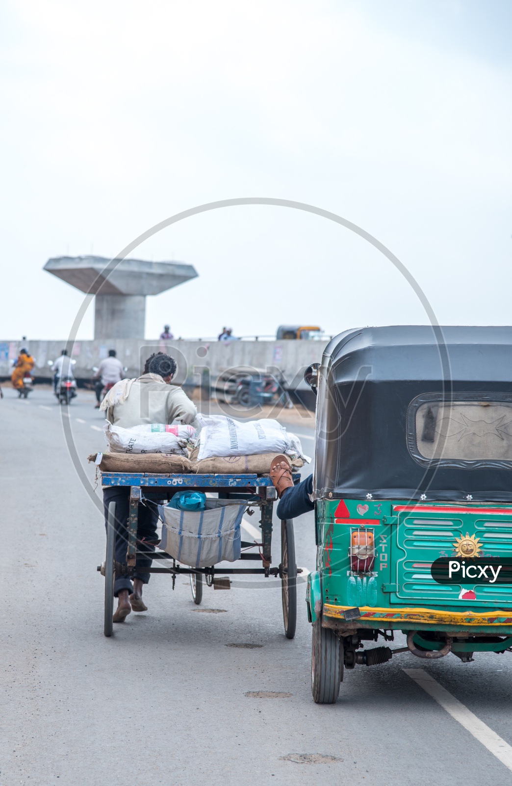 An Auto Driver helping out a Rickshaw Puller on a High Ground.
