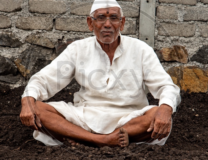 Elderly Farmer poses for a photo in his farm in Maharashtra