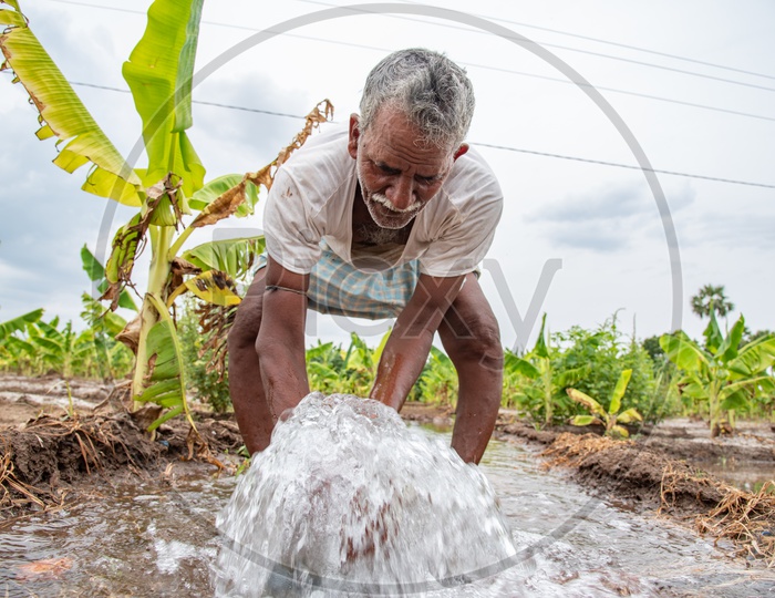 a farmer drinking water from a pumpset in a field
