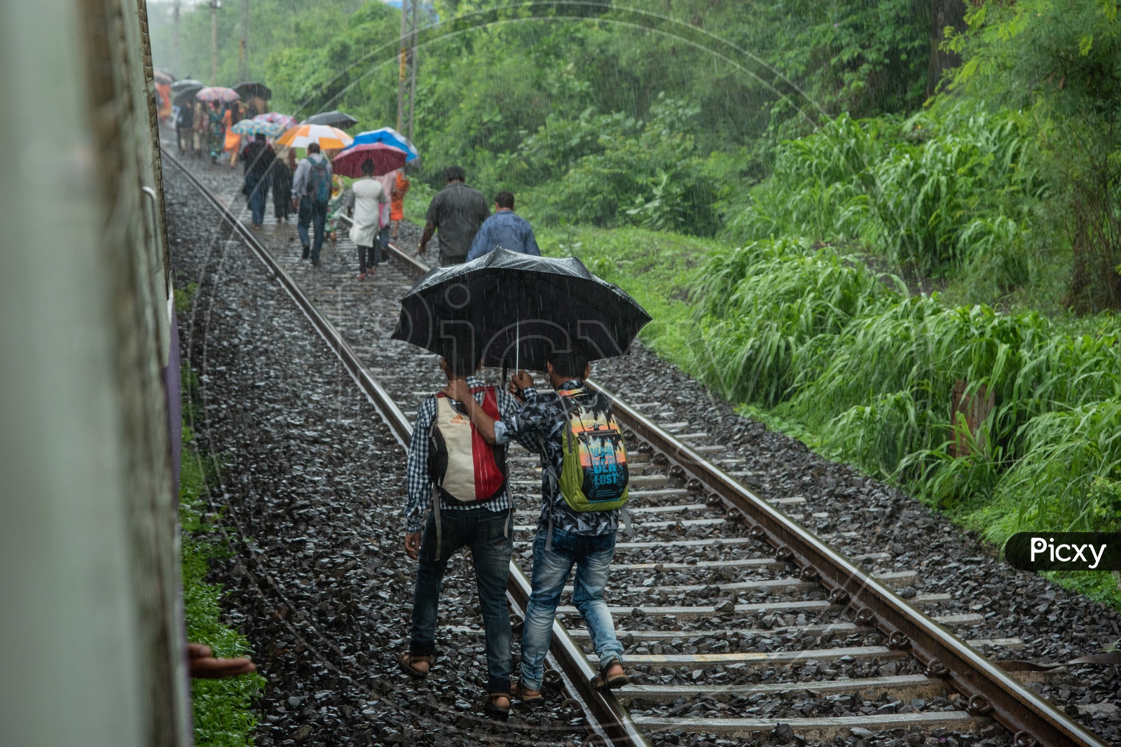 Passengers take to the tracks to reach the nearest station as train breaks down