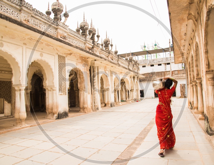 A women carrying water for their household needs at Paigah tombs.