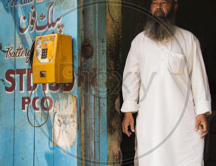 Old Muslim Man runs Public Telephone Booth