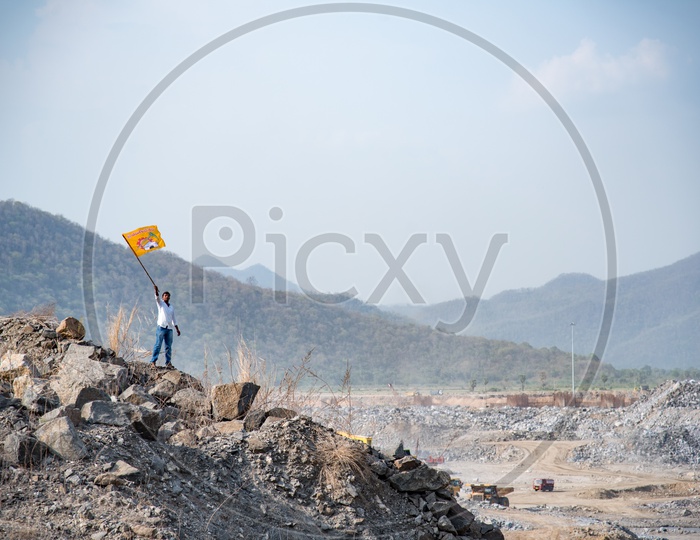 A TDP Supporter Waving TDP Party Flag at Polavaram Irrigation Project Dam Site.