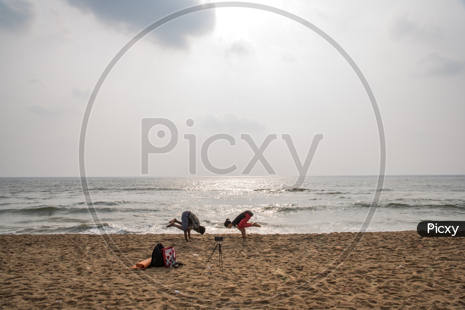 a couple of people  practicing Yoga at Eliotts beach/Besant Nagar Beach,chennai