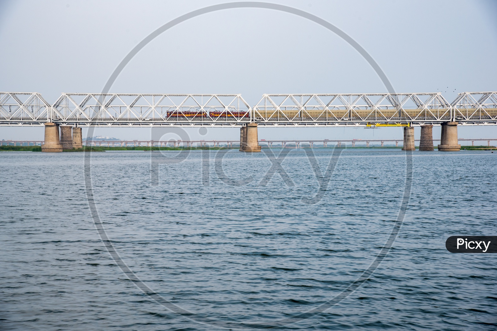 a goods train passing on railway bridge , vijayawada
