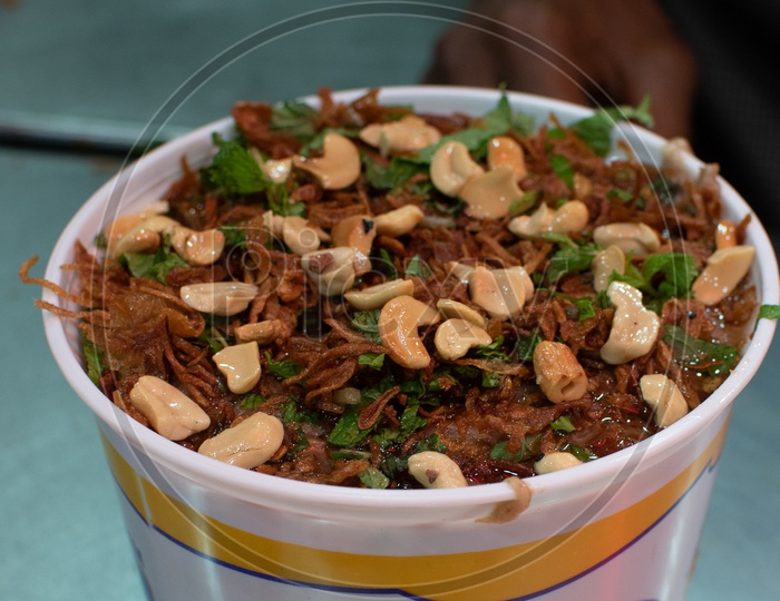 Haleem garnished with Dry fruits, Ghee and Coriander