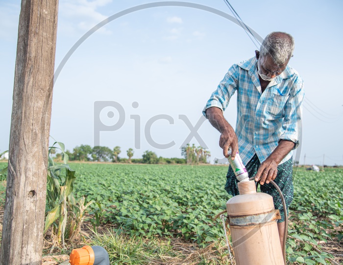 a farmer mixing a pesticide into a Sprayer