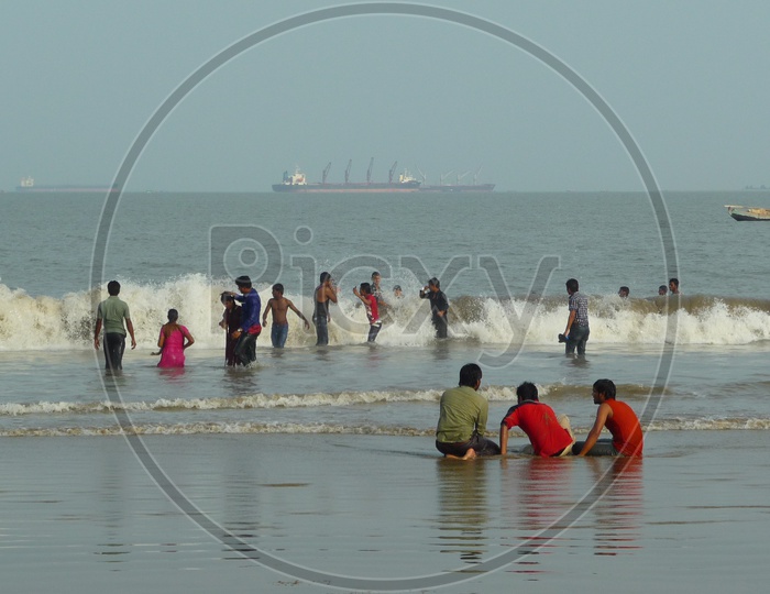 People enjoying waves at Kakinada Beach